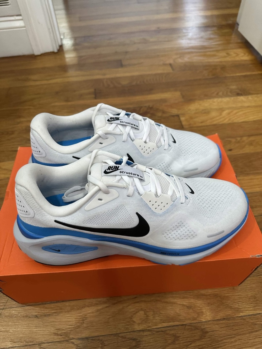 Nike Kids White Sneakers with Blue Accents and Black Swoosh